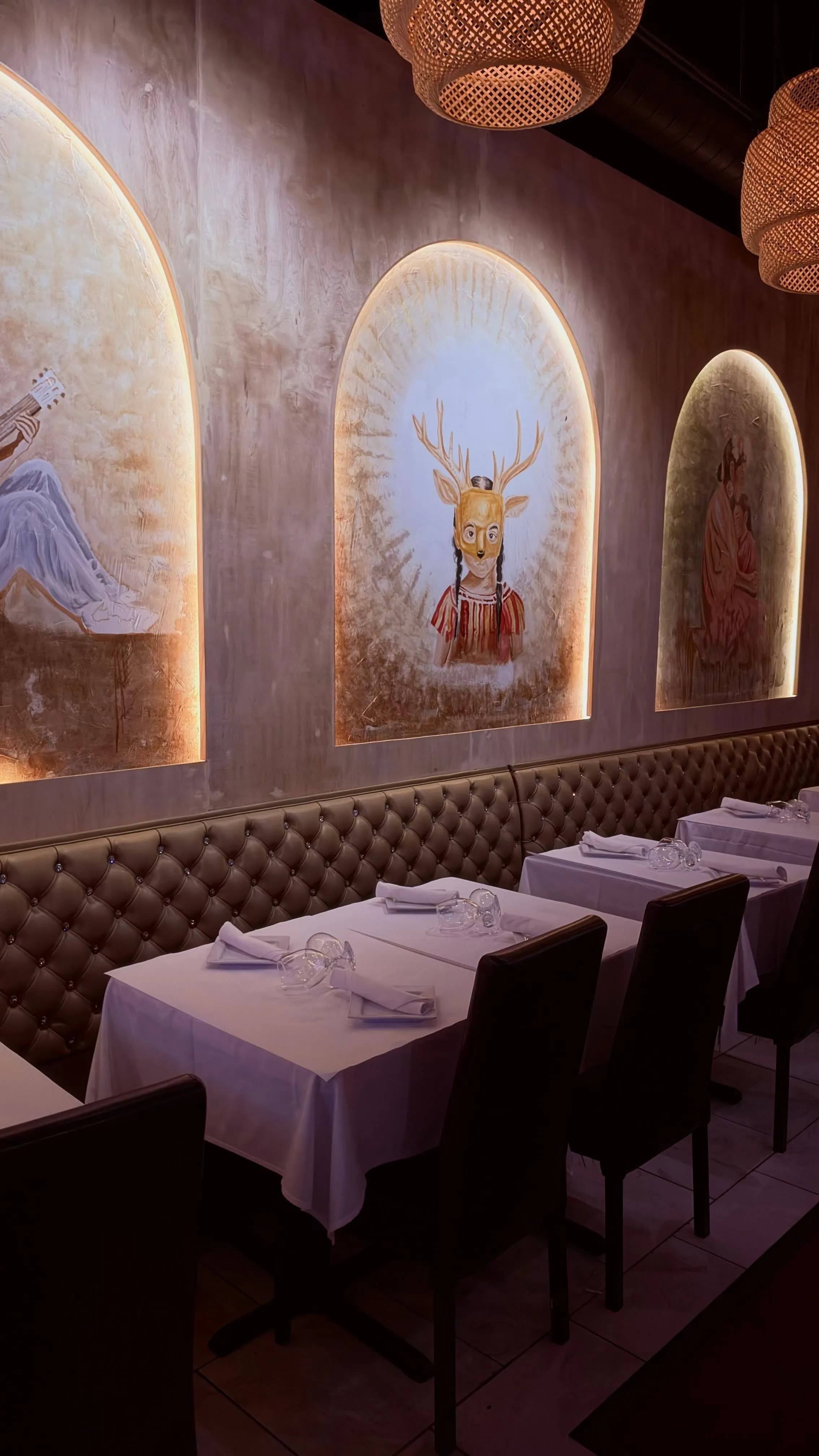 Skull-topped signature cocktail with dry ice smoke against the floral wall at Margaritas Cafe